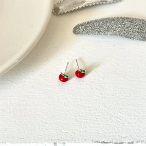 Macro shot of 925 sterling silver cherry stud earrings with red glaze and green leaves