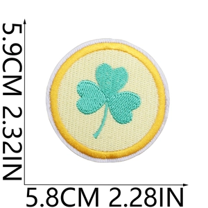 Macro shot of embroidered shamrock patch with size markings for bags and clothing
