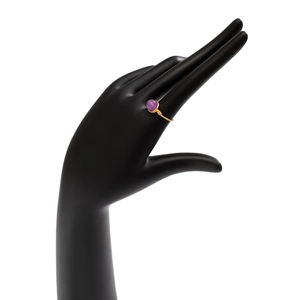 Detail view of handmade gold wire-wrapped ring featuring a polished purple round gemstone