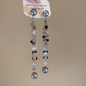 Detail of long tassel earrings with silver and black sequins and elegant grey pearls