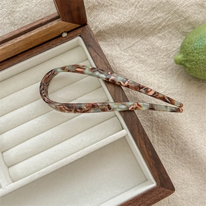 Detail of tortoiseshell acetate U-shaped hair pin on wooden jewelry box