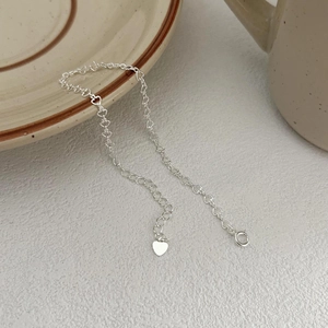 Minimalist 925 sterling silver heart chain bracelet displayed on elegant textured background