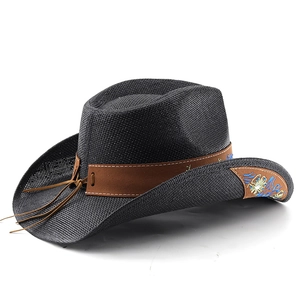Détail d'un chapeau de cowboy en paille noire avec bandeau brodé et ornements en métal
