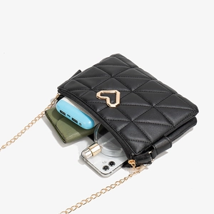 Quilted black crossbody bag with heart detail showing spacious interior for essentials