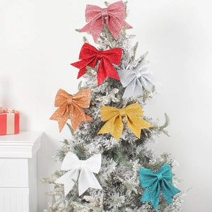 Glittering Christmas bow ornaments in various colors displayed on a festive snowy pine tree