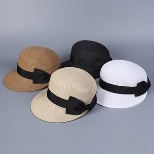 Vista piatta di cappelli equestri in paglia in quattro colori con eleganti fiocchi