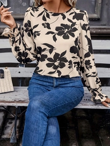 Chemisier fleuri à manches longues dos nu avec jean et sac à main beige tissé