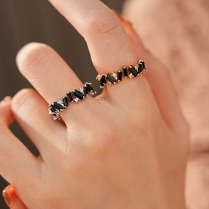 Macro shot of irregular zircon rings with black rectangular stones on a model's hand