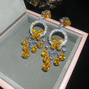 Macro shot of silver earrings with yellow butterflies and sparkling waterdrop gems