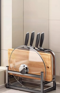 Detail of stainless steel kitchen rack holding a cutting board, pot lid and knives