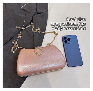 Detailed view of rose gold glitter evening clutch with rhinestone ring buckle and chain