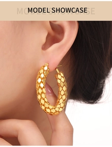 Detail of gold U-shaped hoop earrings with honeycomb texture on model showcase