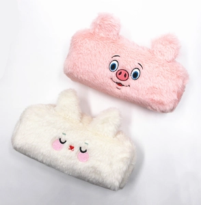 Detail of plush animal pencil cases featuring pink pig and white rabbit with embroidery