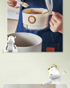 Detail view of a 3-compartment bear seasoning box with spoons and a transparent body