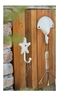 Nahaufnahme von Vintage-Gusseisenhaken in Seestern- und Muschelform im Retro-Stil