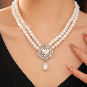 Detail of double-layer pearl necklace with square diamond pendant and teardrop pearl