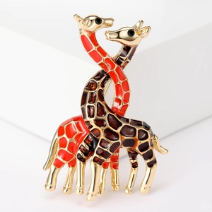 Macro view of double giraffe enamel brooch showing red-orange and brown pattern details