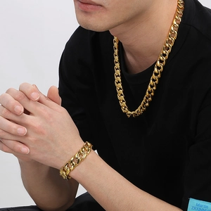 Detail of 15mm gold Cuban link chain set showing thick necklace and bracelet on male model