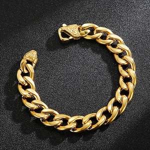 Macro view of golden Cuban link bracelet featuring a decorative embossed square clasp