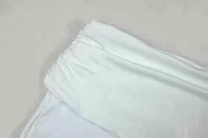Detail of white draped fabric featuring elegant pleats and soft glossy texture