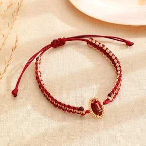Macro detail van de handgeweven rood-gouden football armband met schuifknoopsluiting