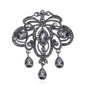 Macro detail of retro alloy insect brooch featuring dark grey crystals and drop pendants