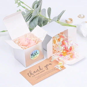 Detail of silver square gift boxes with pearlescent finish and thank you stickers