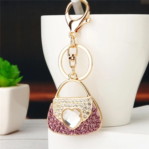 Detailed shot of pink rhinestone handbag keychain with heart crystal on a white cup