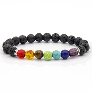 Detailed close-up of colorful 7 chakra beads and black volcanic lava stone on elastic bracelet