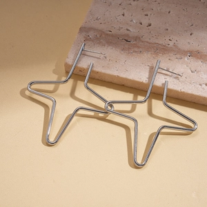 Detail of silver star earrings on natural stone showing hollow geometric design