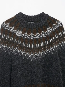 Detailed view of the crew neck collar and vintage geometric jacquard pattern on gray knit sweater