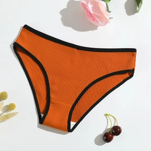 Detailed macro view of orange ribbed cotton panties with black trim and soft texture