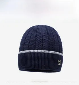 Dettaglio berretto in maglia blu scuro con strisce grigie e logo in metallo