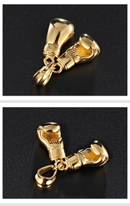 Macro close-up of a polished golden boxing glove pendant with shiny metallic details