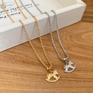 Macro detail of gold and silver rocking horse pendants with hammered texture finish