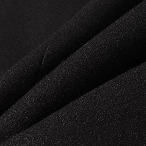 Vue macro d'un tissu en laine noir montrant le grain fin et des ombres douces