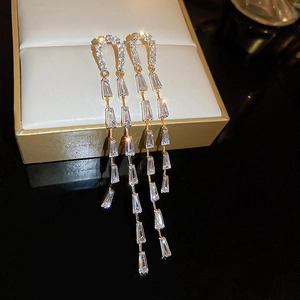 Close-up of elegant gold tassel earrings featuring sparkling cubic zirconia stones