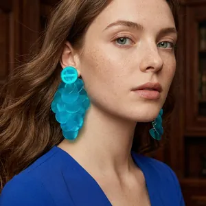 Gros plan de boucles d'oreilles en raphia bleu à plusieurs couches sur un mannequin
