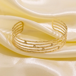 Detail of 14K gold plated layered cuff bracelet with hammered texture and zircons
