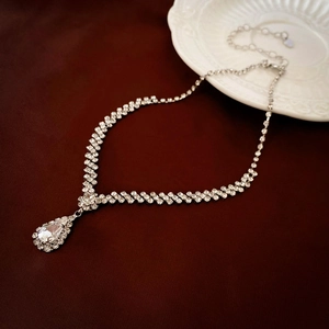 Close-up of silver teardrop rhinestone necklace with shimmering crystal tassels on jewelry tray