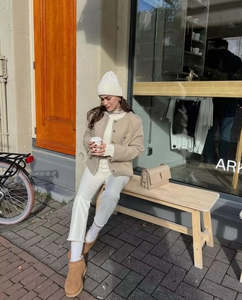 Outdoor street style showing beige cardigan and cream hat on a model for a casual look