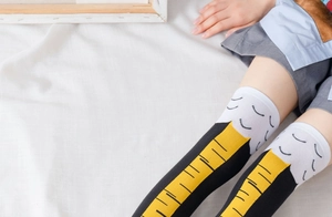 Close-up of creative over-the-knee socks with yellow and black geometric patterns