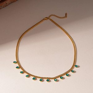 Detail of gold necklace featuring twelve green teardrop charms on a delicate chain