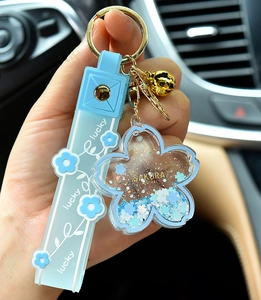 Detailed view of light blue Sakura liquid shaker keychain with glitter and strap