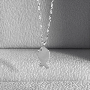 Detailed macro view of S925 sterling silver minimalist fish pendant with fine link chain