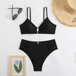 Detail of black bikini set with gold ring connector and high-waisted ruched bottoms