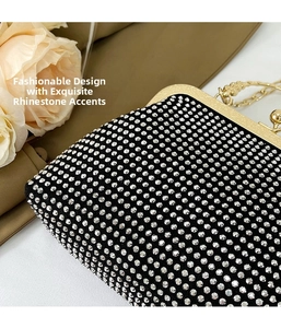 Close-up of elegant black party clutch with sparkling silver rhinestones and gold clasp