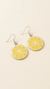 Detail showing lemon slice dangle earrings in yellow on a rustic textured surface