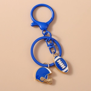 Detailed view of blue rugby helmet and ball keychain with golden metal trim details