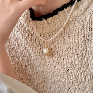 Elegant 925 sterling silver pearl necklace with oval pendant worn on model neck